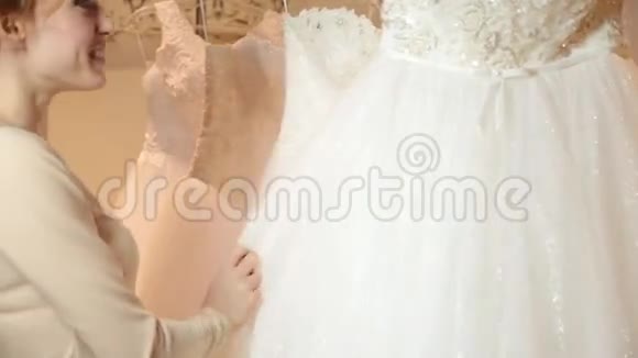 年轻的红发女人选择婚纱在新娘精品店准备结婚的新娘视频的预览图