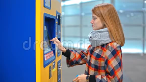 年轻女子正在用自动售货机买票选择触摸屏视频的预览图