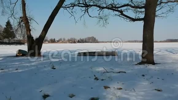 冬天无人机在雪湖海岸和船上空飞行空中飞行视频的预览图