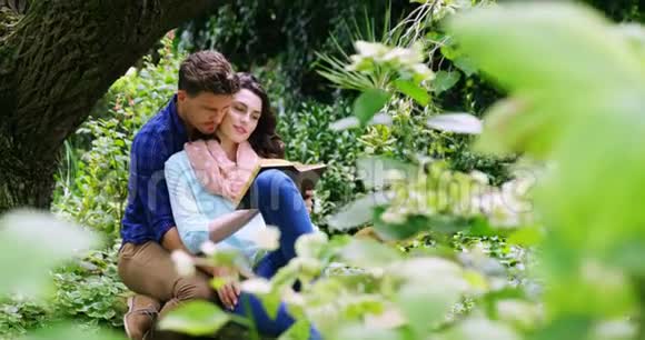 浪漫情侣在公园里读小说视频的预览图