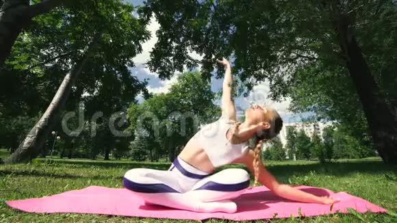 健身妇女躺在夏季公园的瑜伽垫上健身女性准备健身视频的预览图