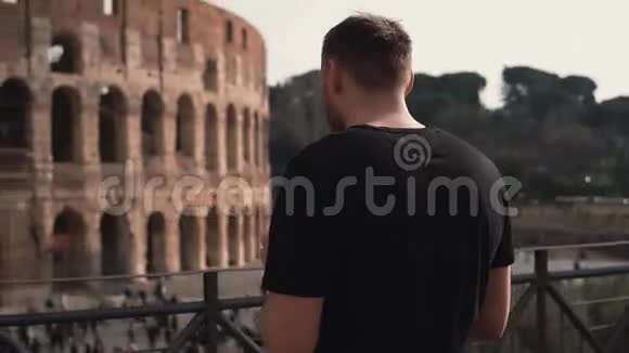男子游客站在意大利罗马竞技场帅哥拿智能手机服务于互联网慢动作视频的预览图