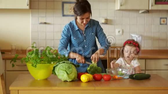 小女儿帮妈妈做饭他们切花椰菜素食汤健康的生活方式素食家庭健康视频的预览图