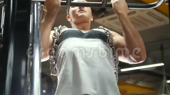 健身馆里的健美运动员用金属链对肱二头肌进行牵拉视频的预览图