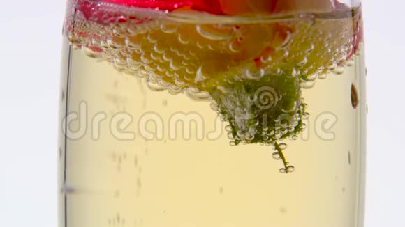 玻璃杯里的玫瑰花蕾装满了香槟白色背景关门视频的预览图