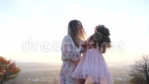 快乐的孩子冲进母亲的手中妈妈把她的女儿旋转视频的预览图