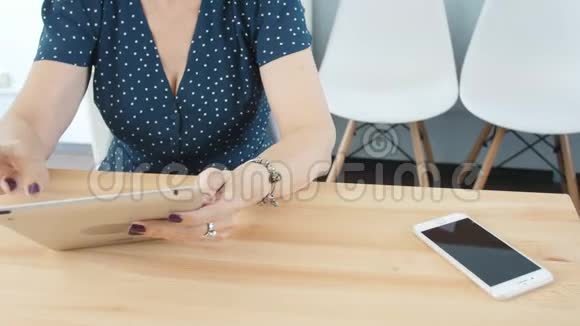 办公室里一个中年妇女用平板电脑视频的预览图