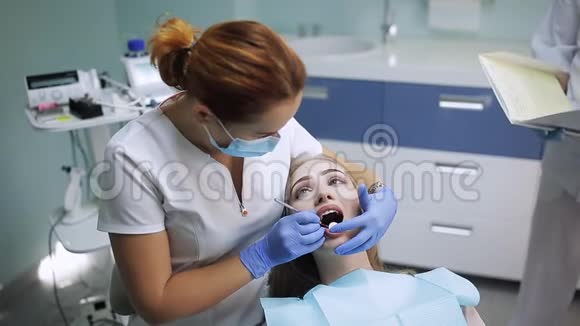 戴口罩的女性口腔医生女医生在工作病人照镜子视频的预览图