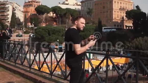 中年帅哥看照片在意大利罗马拍照微笑探索新城市慢动作视频的预览图