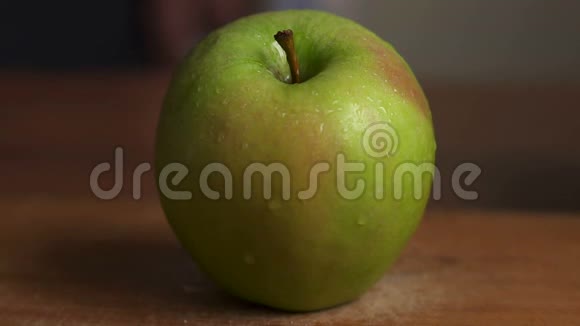 木桌上有水滴的绿苹果视频的预览图