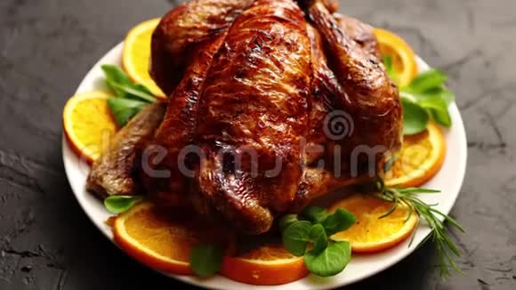 烤全鸡或火鸡用白色陶瓷盘子配上橙子视频的预览图