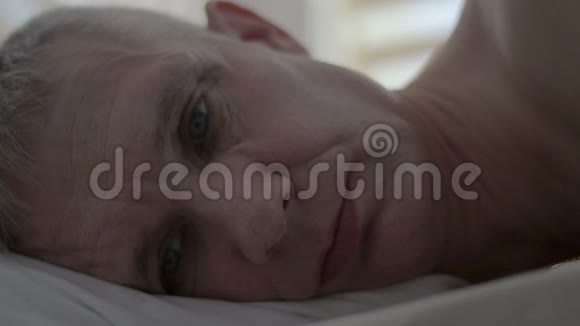 一个不成功的性行为后躺在床上的沮丧男人的脸视频的预览图