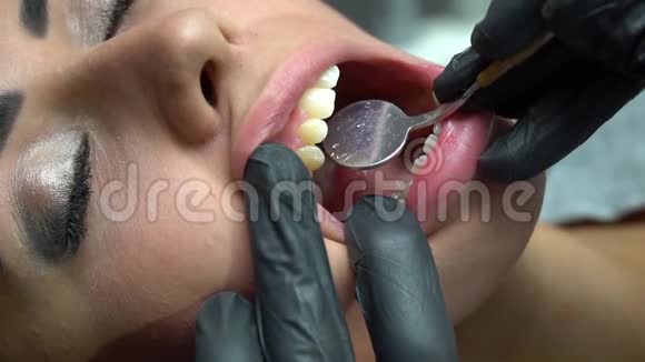 在牙科医生为一个病人做一个检查和一个牙齿清洁的特写牙医检查一个年轻人的牙齿视频的预览图