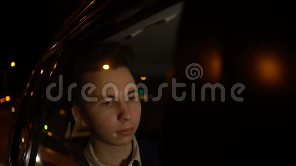 年轻英俊的少年在夜间城市和司机一起乘坐出租车旅行的肖像4k个镜头视频的预览图