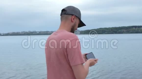 男人在湖边慢动作拍照视频的预览图
