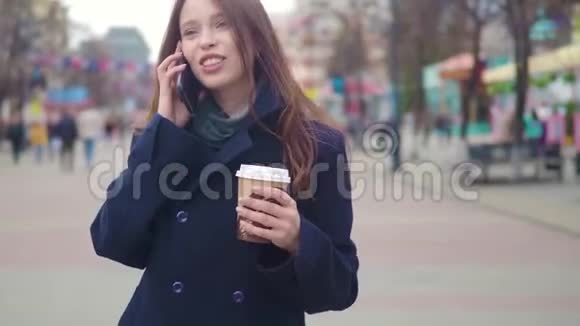 多莉拍摄了一张吸引人的混合种族商务女性在城市街道上谈论智能手机和喝咖啡的照片视频的预览图