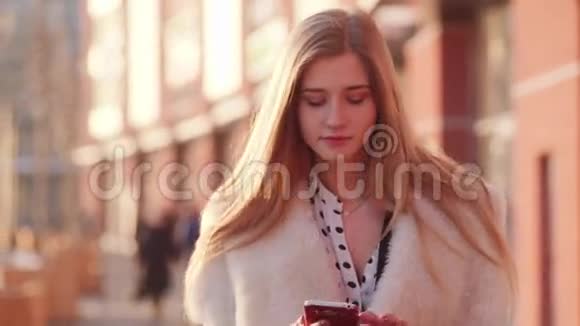 美丽漂亮的女孩在市中心阳光明媚的街道上一边打电话一边笑视频的预览图