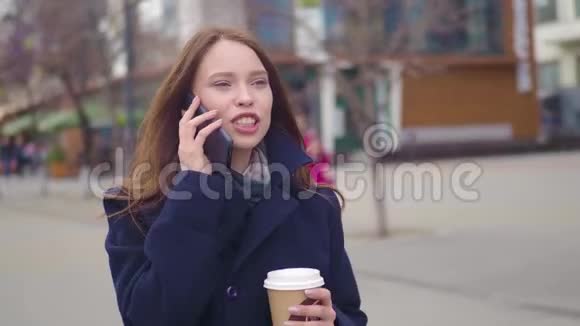 多莉拍摄了一张吸引人的混合种族商务女性在城市街道上谈论智能手机和喝咖啡的照片视频的预览图
