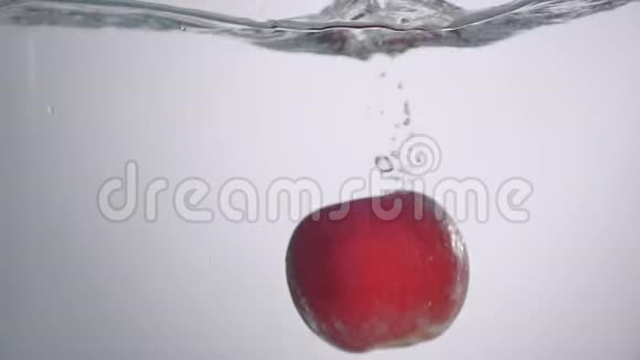 小水滴从新鲜的红苹果掉进水里有小的圆形波浪和小的飞溅视频的预览图