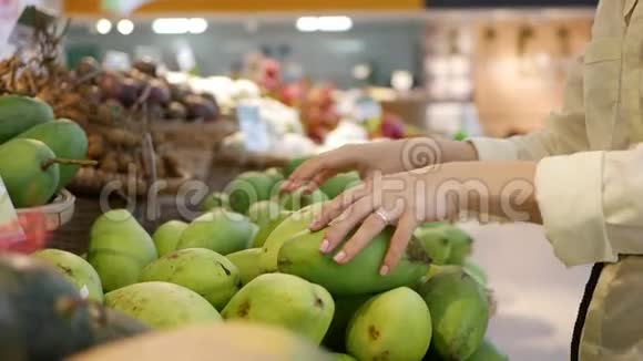 女人们在超市里挑选新鲜芒果视频的预览图