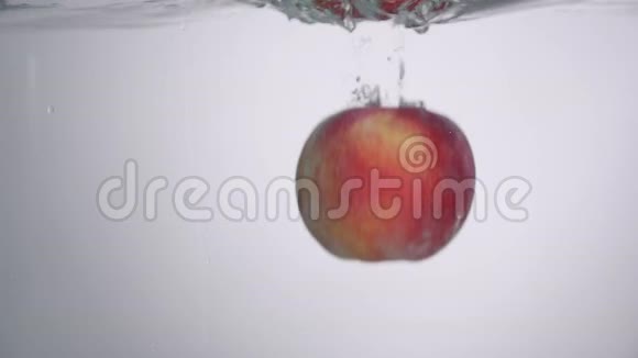 小水滴从新鲜的红苹果掉进水里有小的圆形波浪和小的飞溅视频的预览图