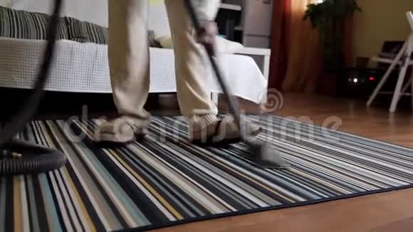 年轻女子在打扫房子里的地毯时使用吸尘器房屋清洁视频的预览图
