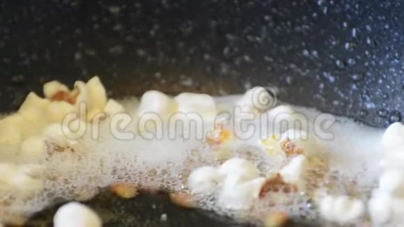 特氟龙锅特写中的热油爆米花视频的预览图