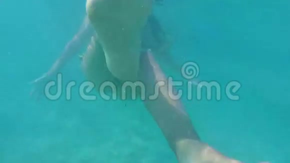 美丽的女孩在比基尼游泳水下和移动脚在镜头前去专业高清慢动作视频的预览图