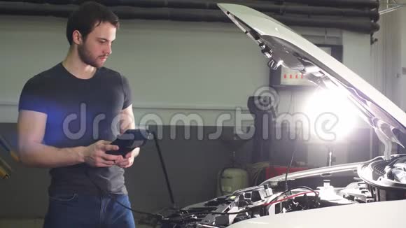 年轻的技术人员在车库做汽车发动机服务视频的预览图