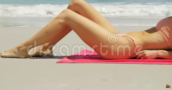 戴帽子的白人女性在海滩上放松的侧面景色视频的预览图