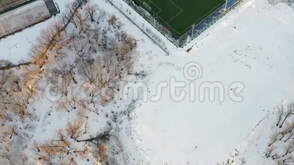 业余足球场的空中射击在冬天拍摄了一个白色布局的现代足球场4k个镜头视频的预览图