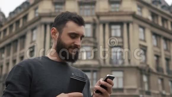 男人检查他的智能手机喝咖啡视频的预览图