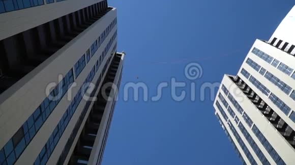 一个男人坐在摩天大楼之间的紧身裤上视频的预览图