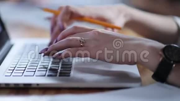年轻漂亮的商务女性在轻盈的现代办公室里用笔记本电脑打字3尽管她工作了很长时间她仍在努力工作视频的预览图