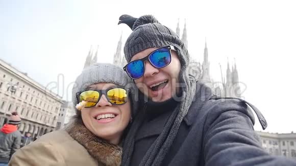 快乐的游客和鸽子在米兰的多摩大教堂前拿着一张带电话的自我画像冬季旅行概念视频的预览图
