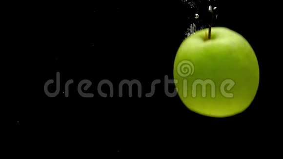 红苹果和绿苹果在黑色的背景下落入透明的水中视频的预览图