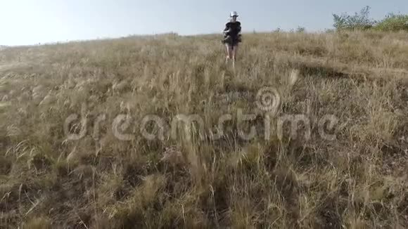 一个背着背包的女孩从一个陡峭的斜坡上逃跑了视频的预览图