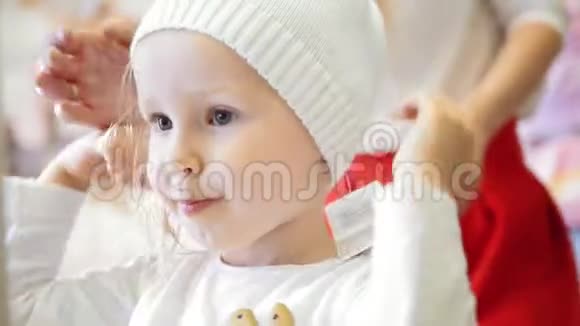 一个快乐的小女孩妈妈在孩子们的服装店买了一顶粉红色的帽子视频的预览图