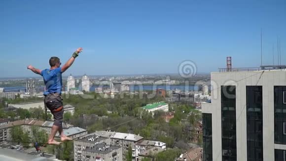 一个人用紧绳平衡从高处俯瞰整个城市视频的预览图