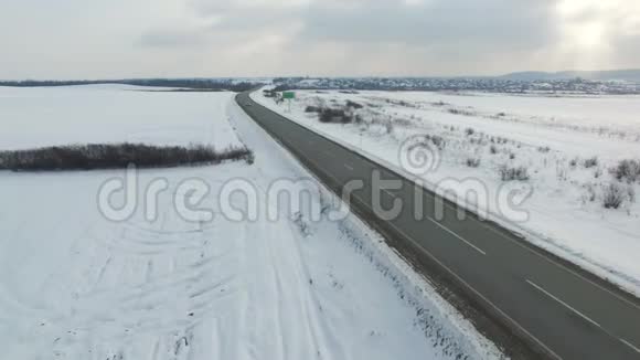 冬季阴天在公路上行驶的汽车和卡车的空中射击视频的预览图