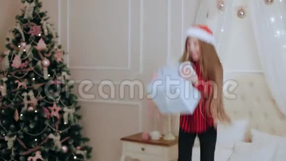 一个穿着礼品盒跳在床上的小女孩视频的预览图