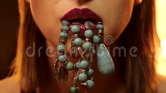 年轻漂亮的女人嘴唇上贴着宝石首饰项链上面贴着紫水晶珠视频的预览图