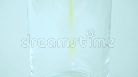 白色背景透明玻璃中倒入黄色橙色的缓慢过程视频的预览图