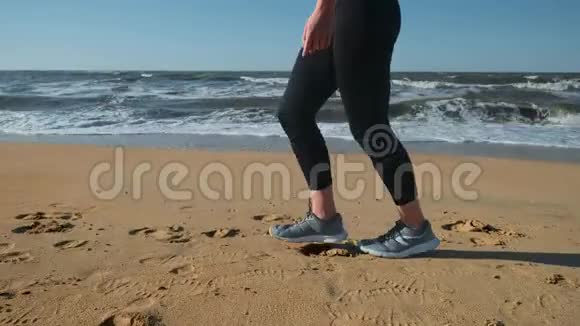 20岁的女孩在日落时在沙滩上奔跑在户外慢跑视频的预览图