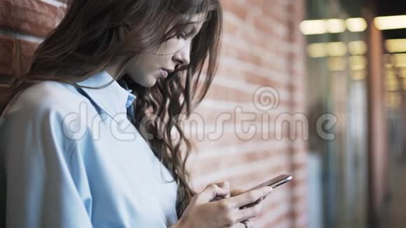 年轻女子在办公室大厅发短信视频的预览图