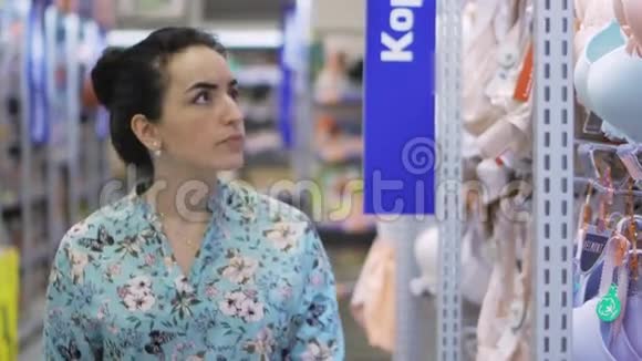 漂亮的黑发女士选择内衣在商店漂亮的女人在超市里考虑胸罩漂亮女人视频的预览图