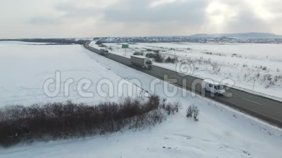 冬季阳光明媚的一天卡车在公路上行驶的空中射击无人机沿道路移动视频的预览图