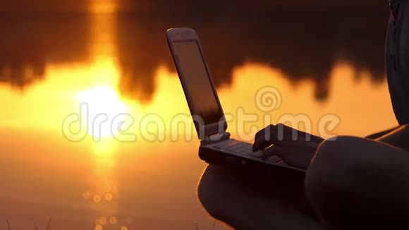 夜间湖岸户外笔记本电脑上的男性手指视频的预览图