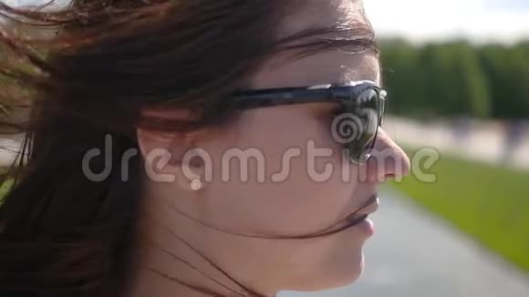 戴太阳镜的女孩在镜头前摆姿势头发在风中发展慢动作1920x1080全高清视频的预览图