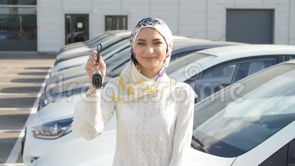 买车的概念幸福的穆斯林女人拿着车钥匙视频的预览图